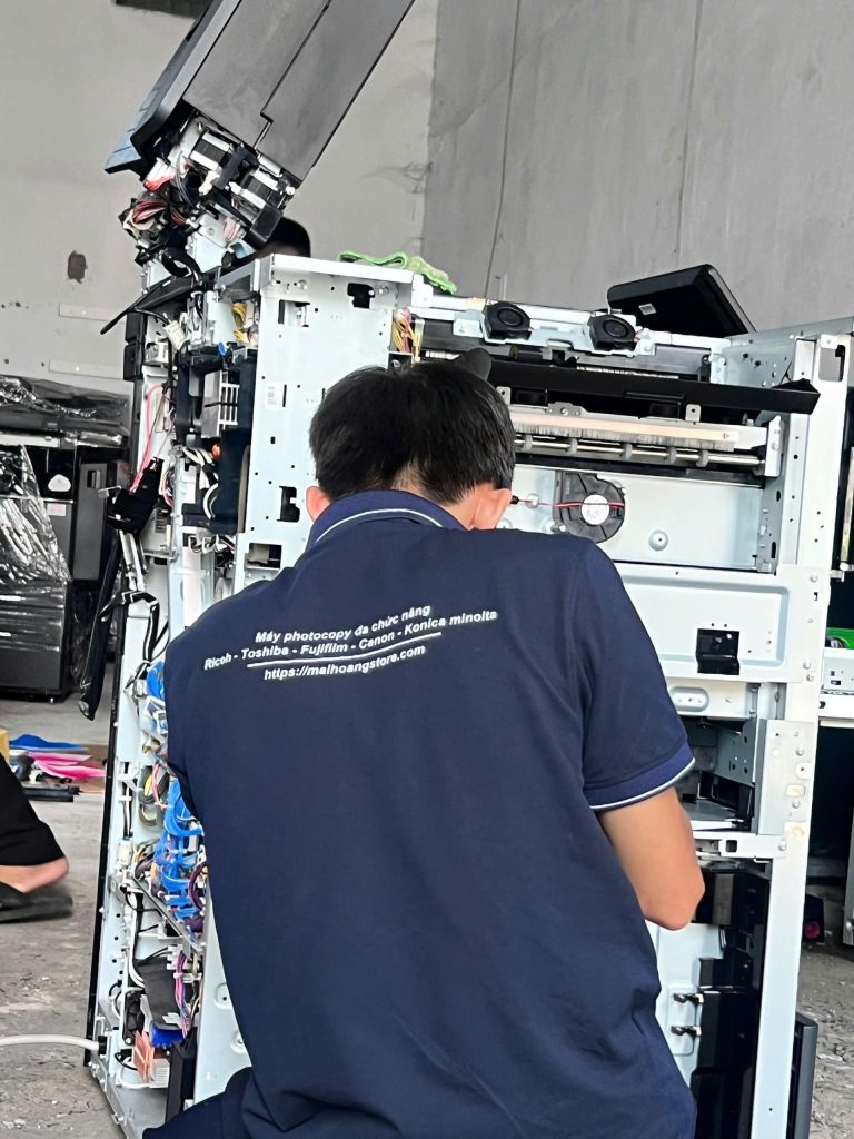 Kỹ thuật viên kiểm tra bên trong máy photocopy